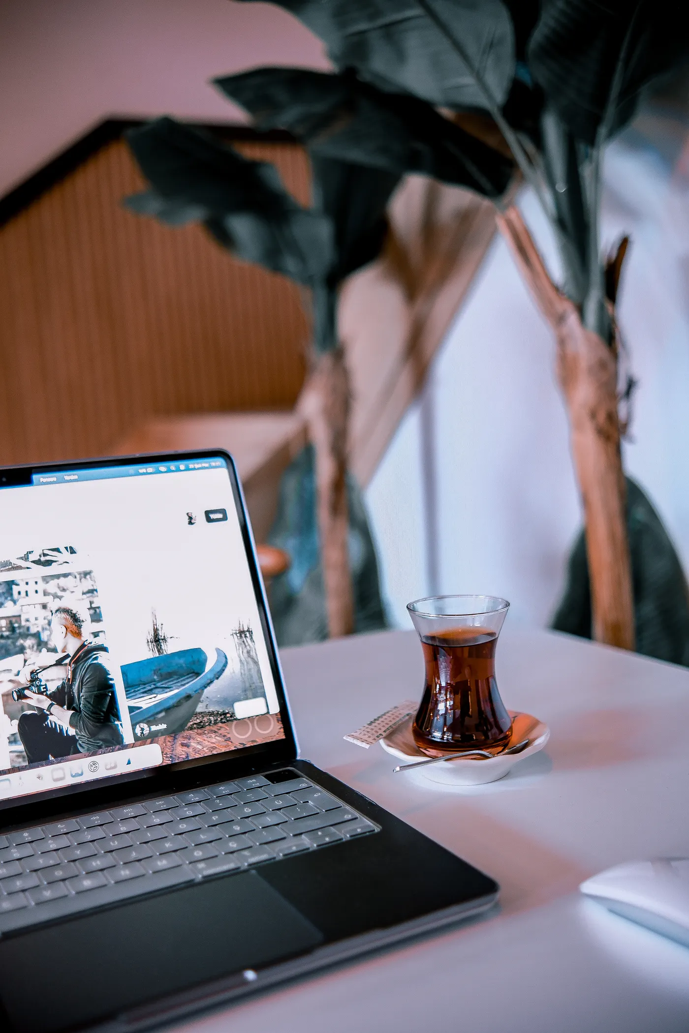 Dizüstü bilgisayarın yanında Türk çayı bulunan çalışma masası